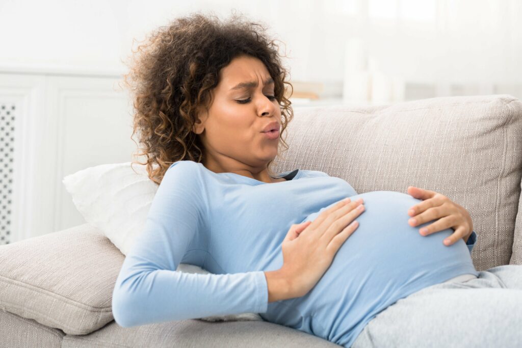 Shows a pregnant woman breathing through a contraction