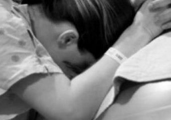 Woman in labor using a stability ball while being supported by her birth doula.